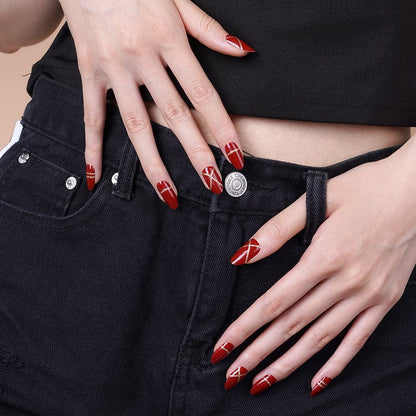 Glossy red nail wraps with metallic gold detailing on hands for luxury nail art