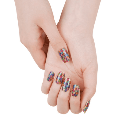 Hands showcasing rainbow holographic nail wraps with iridescent scale pattern nail art