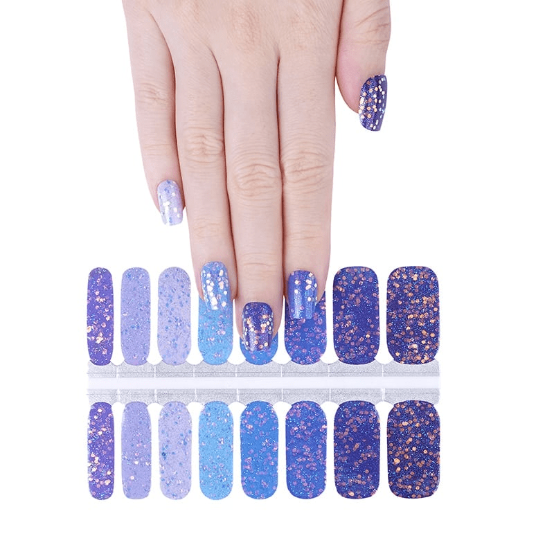 Blue glitter ombre nail wraps displayed with hand showing sparkly gradient manicure design