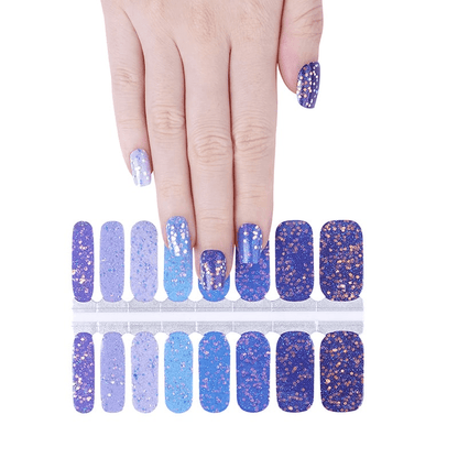 Blue glitter ombre nail wraps displayed with hand showing sparkly gradient manicure design