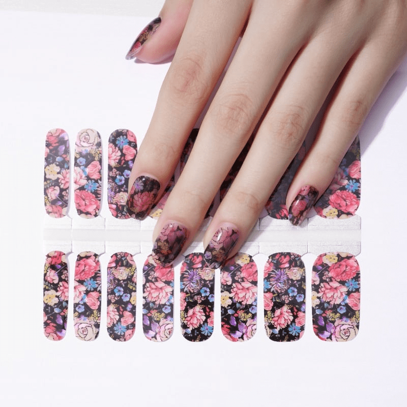 Vintage dark floral nail wraps on hand featuring pink roses and blue flowers