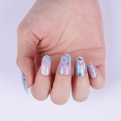 Nail wraps with pastel blue and lilac daisy florals on shimmery white base