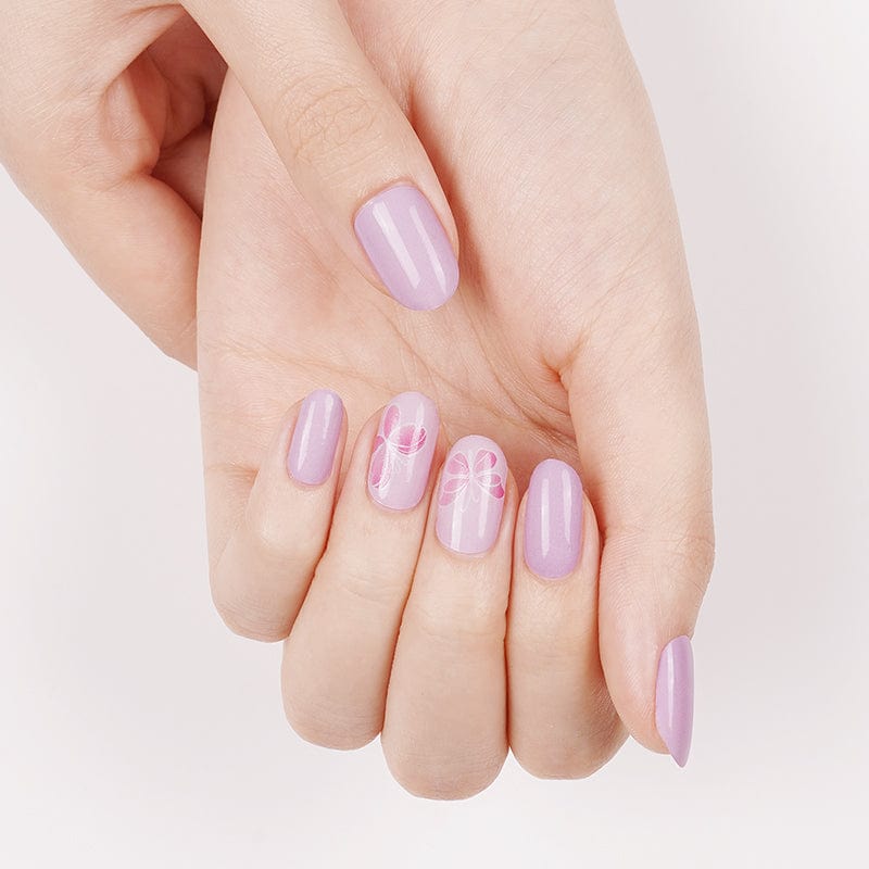 Lilac glossy non-UV nail wraps with delicate pink bow accents on select nails