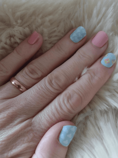 Holy Classics nail wraps in pink and blue, with cloud and kite motif accents.