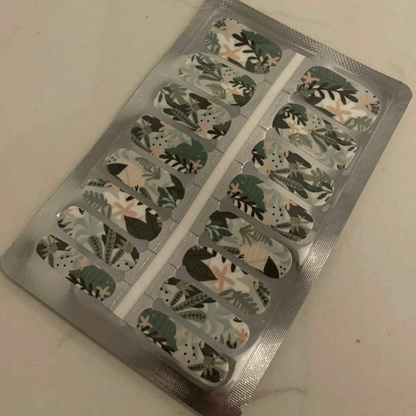 Nail wraps with green and cream tropical leaf print on white, botanical design