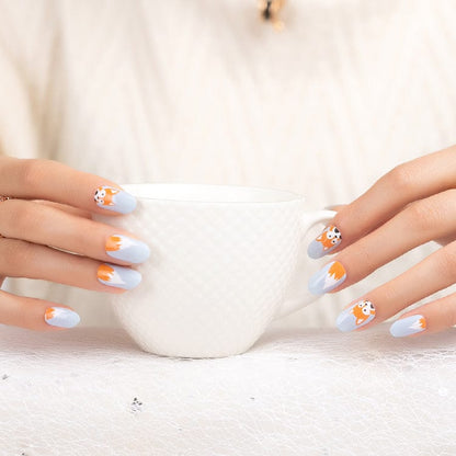 Grey and orange fox nail art wraps on hands holding white mug