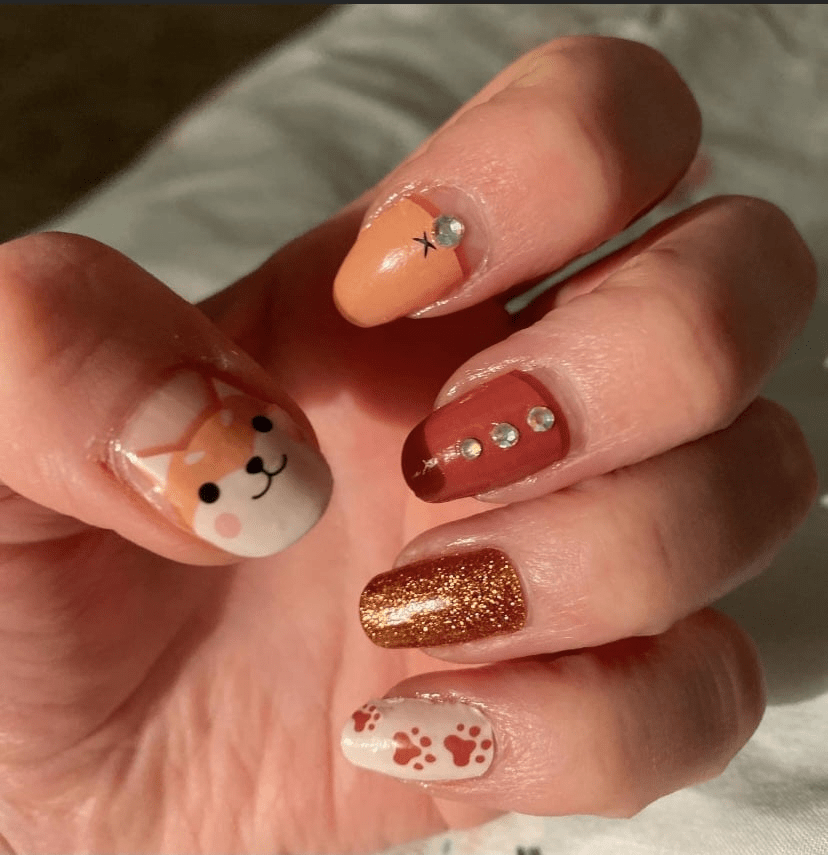 Autumn fox nail wraps featuring cute characters and brown glitter on hand