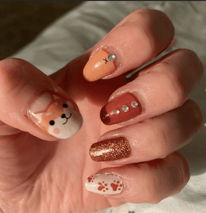 Autumn fox nail wraps featuring cute characters and brown glitter on hand