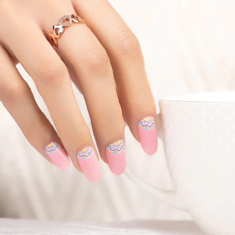 Pink matte nail wraps with pastel floral lace design at the cuticle line