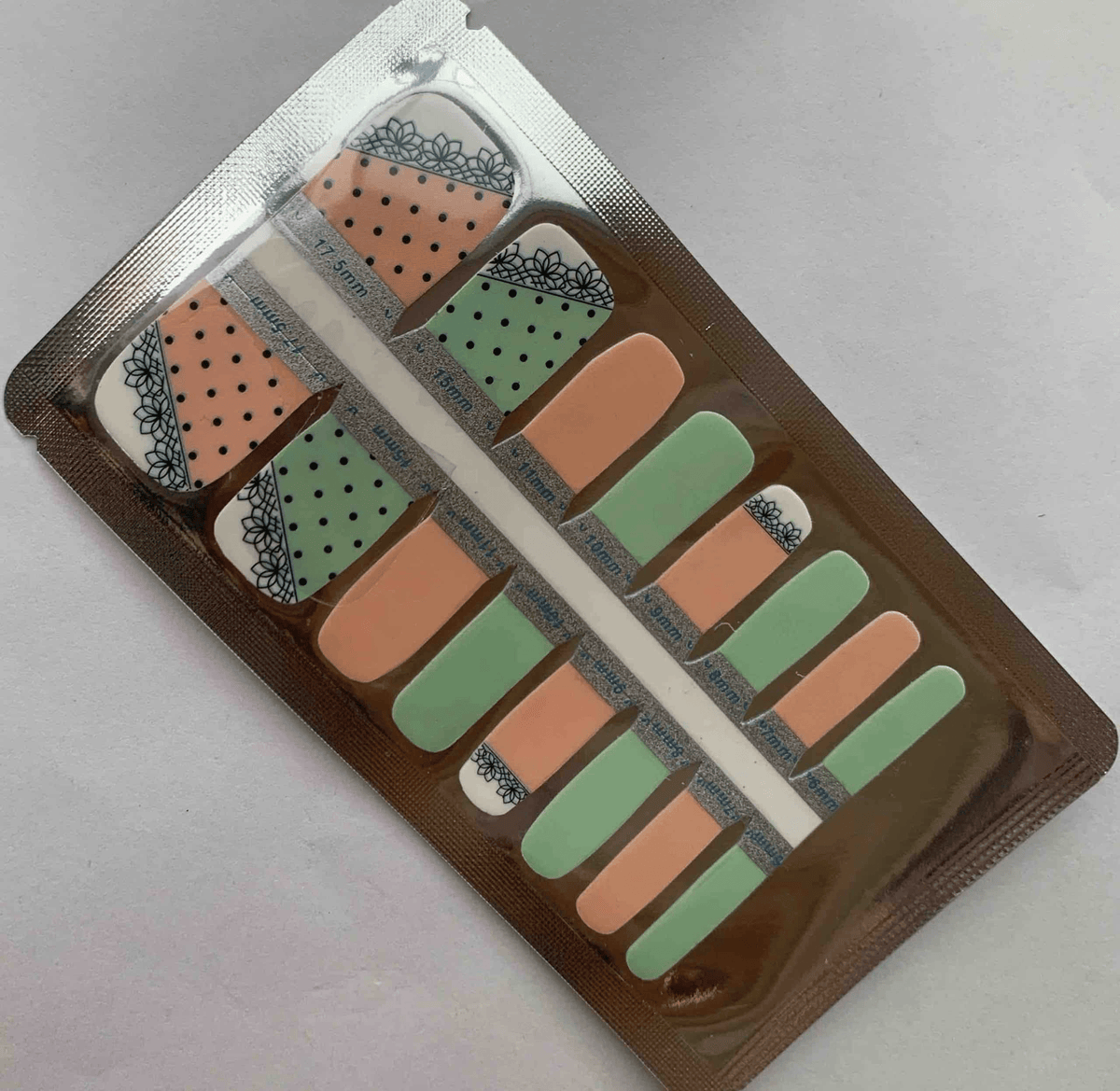 Packaged pedicure nail wraps in pink and green with polka dot lace patterns for toes