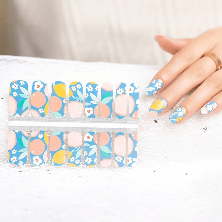 Blue nail wraps with citrus fruit, peach circles and white floral print