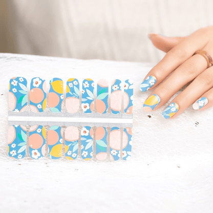 Blue nail wraps with citrus fruit, peach circles and white floral print