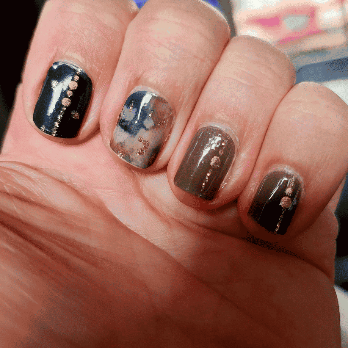 Navy and grey marbled nail wraps with metallic rose gold speckled accents, glossy finish.