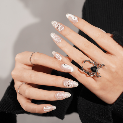Sheer nail wraps with white spiderweb, drip, and ghost motifs, almond shape
