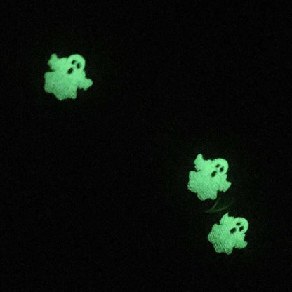 Green glowing ghost nail wraps demonstrating glow in the dark effect on black background