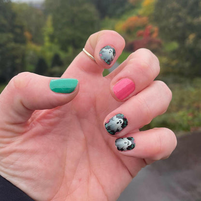 Spooky Halloween manicure featuring ghost nail art and solid colour nail wraps on hand