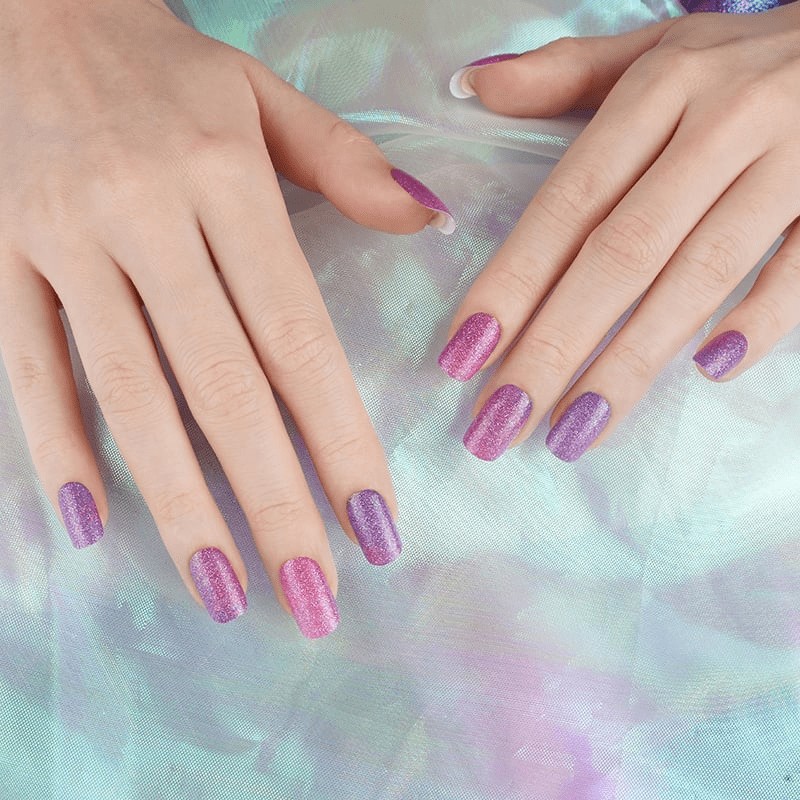 Hands showing purple glitter galaxy nail wraps with cosmic sparkle finish at-home manicure