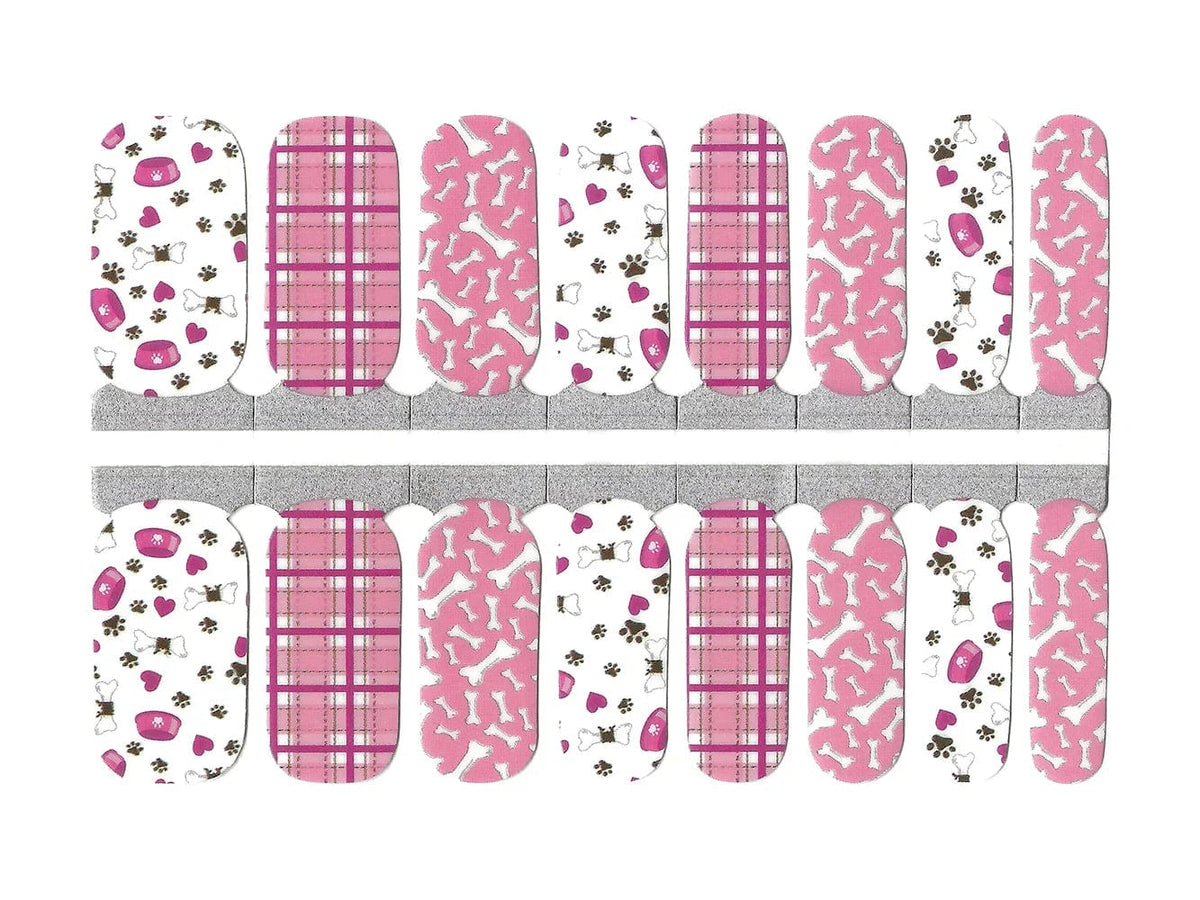 Pink and white nail wraps with dog bones, paw prints, plaid and pet bowl motifs