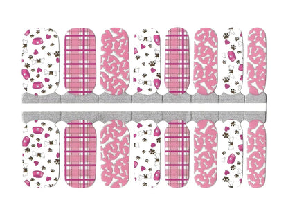 Pink and white nail wraps with dog bones, paw prints, plaid and pet bowl motifs