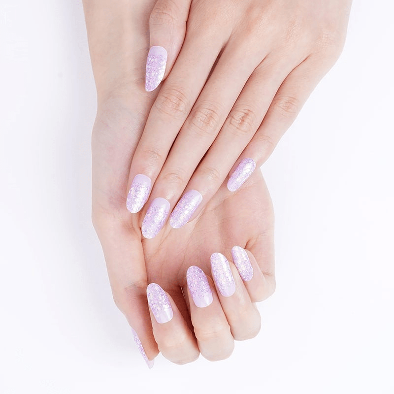 Pale pink glitter nail wraps on hands with sparkly gradient finish for at-home manicure