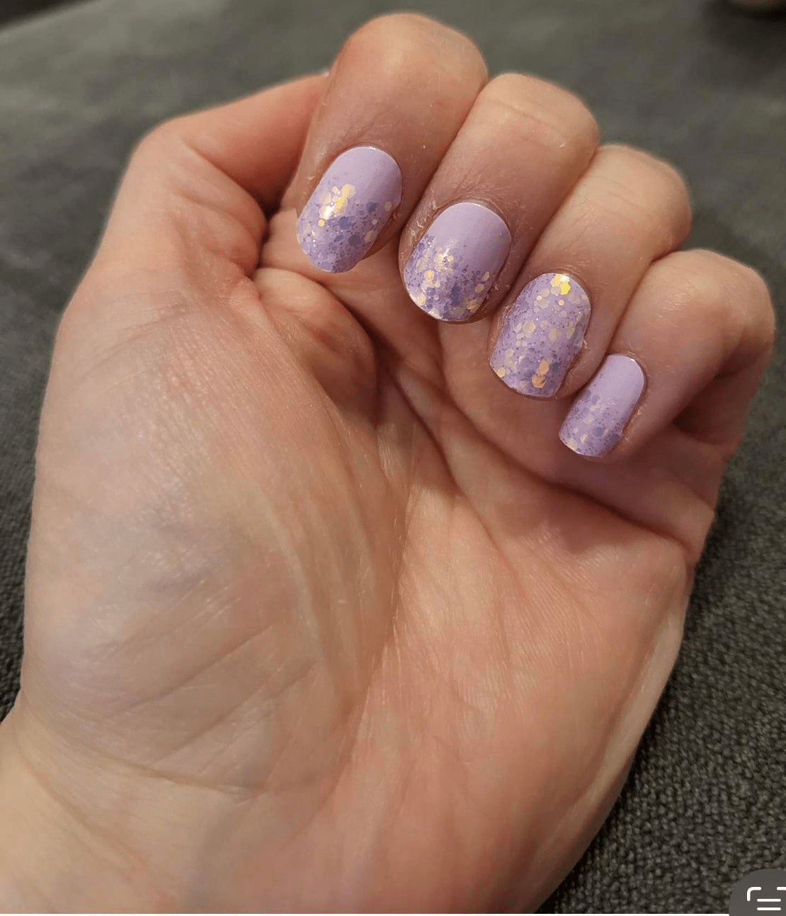 Lilac nail wraps with gold and purple glitter speckled tips on a matte base