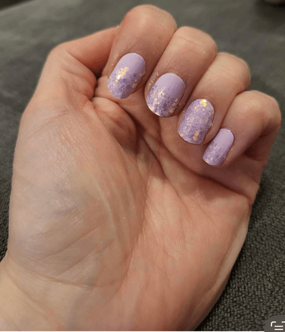 Lilac nail wraps with gold and purple glitter speckled tips on a matte base