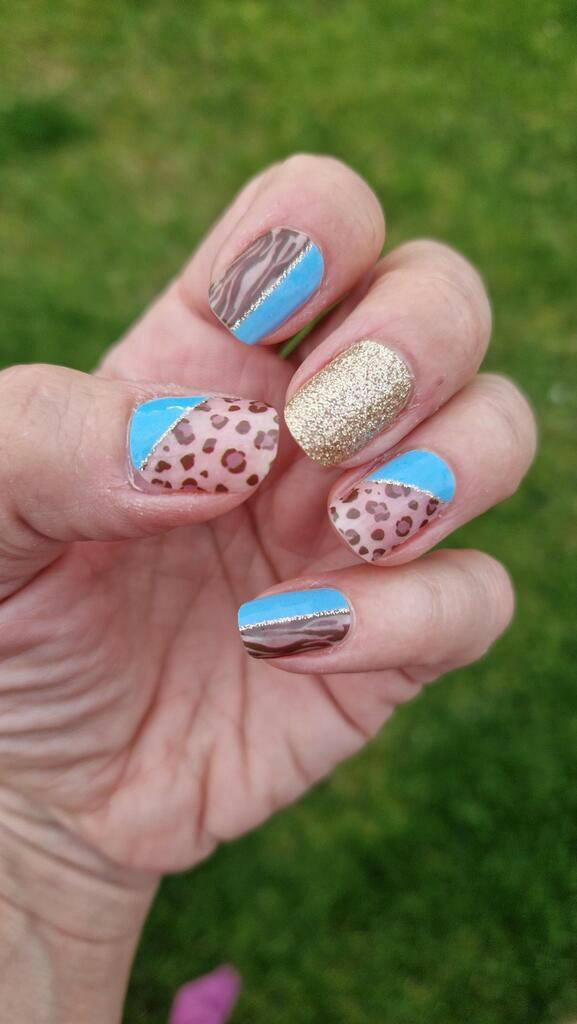 Powder blue and gold glitter nail wraps with leopard print on hand manicure