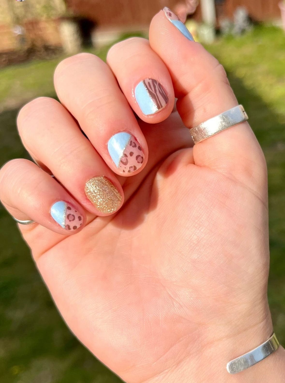 Mixed pattern nail art featuring blue leopard print and gold glitter nail wraps
