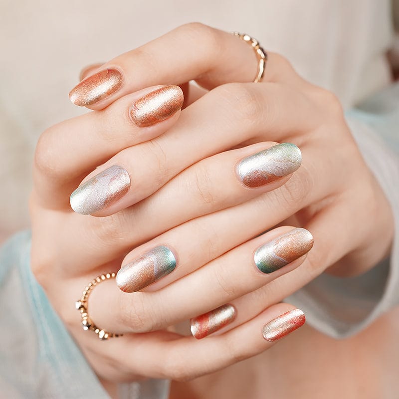 Rose gold and silver chrome nail wraps on hands creating elegant metallic manicure