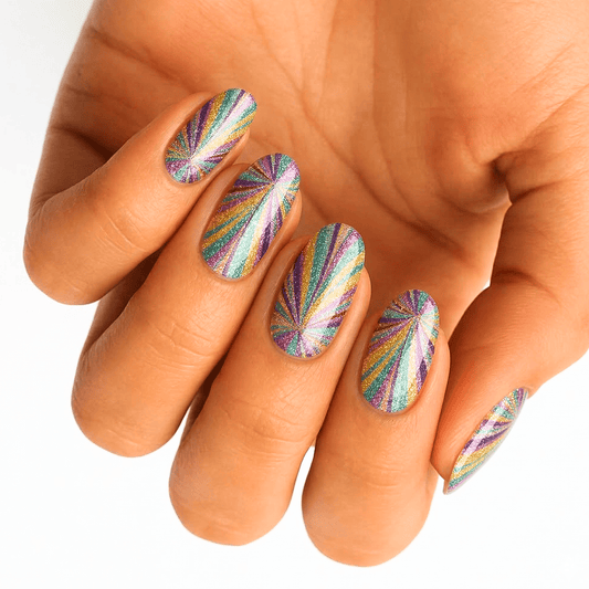 Rainbow holographic nail wraps with radiating sunburst pattern on hand showing multicoloured nail art design