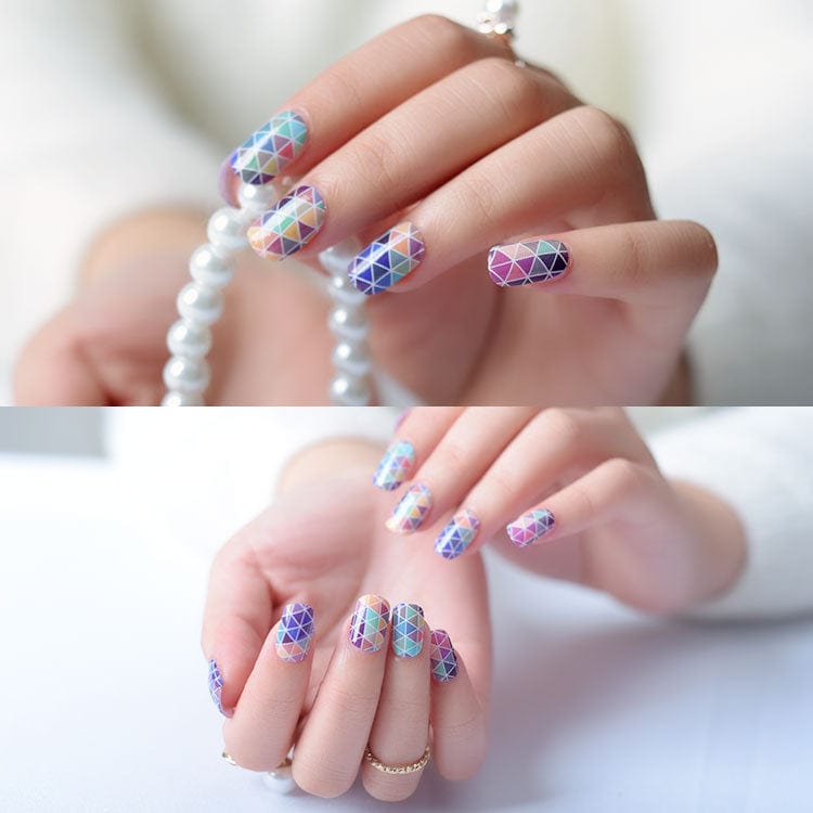 Triangle pattern nail wraps on hands displaying purple pink geometric mosaic design