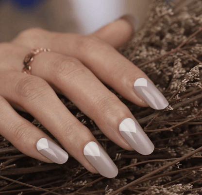 Hand wearing grey mountain geometric nail wraps with white triangle pattern design