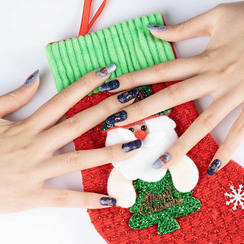 Hands wearing Christmas nail art wraps holding festive decorations with snowman design
