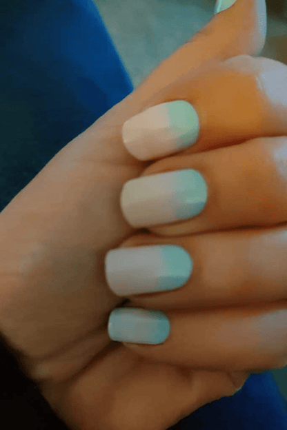 Pastel ombre nail wraps on hand with blue to pink gradient manicure design