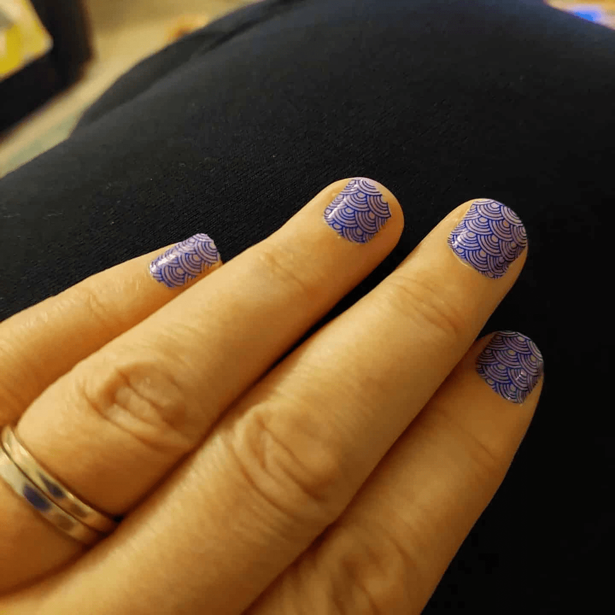 Navy blue scalloped pattern nail wraps worn on fingernails geometric design