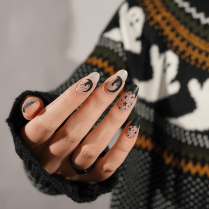 Nail wraps with sheer base, black crescent moons, stars and glittery French tips