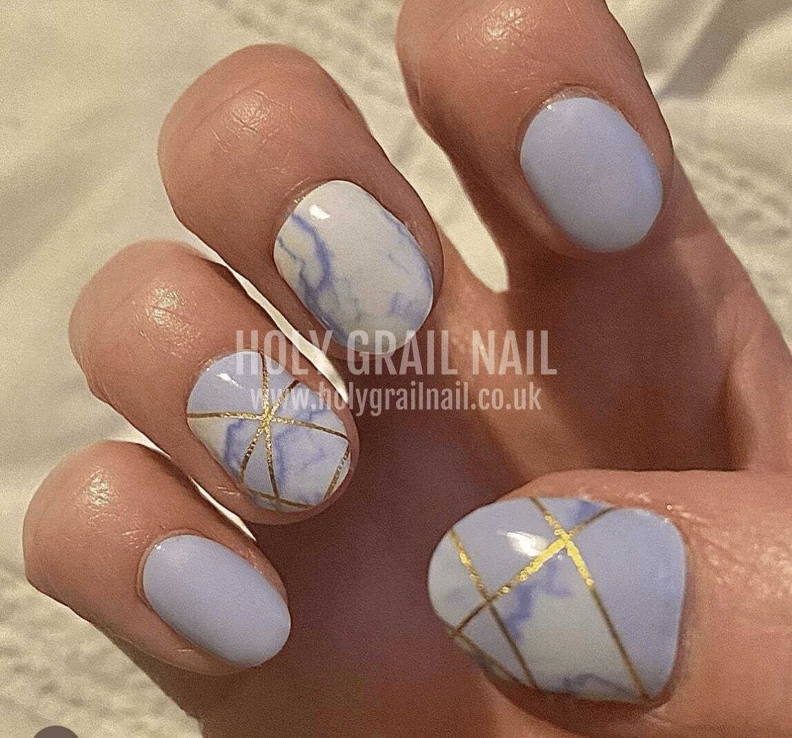 Pale blue nail wraps with marble effect and gold geometric line accents, wide fit