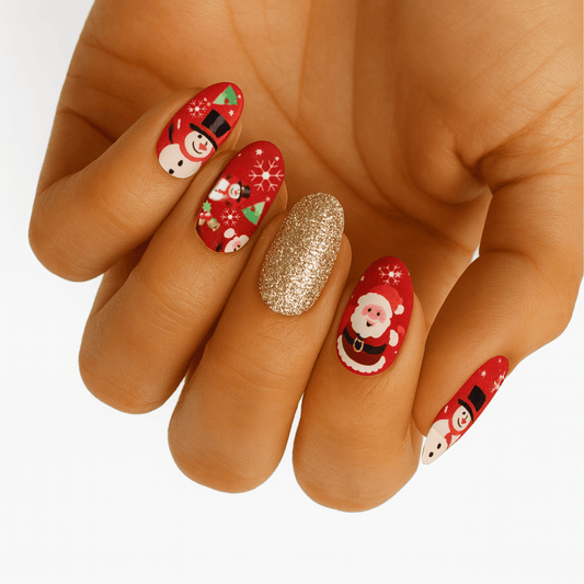 Hand wearing festive Christmas nail wraps with Santa, snowmen and gold glitter accent nail