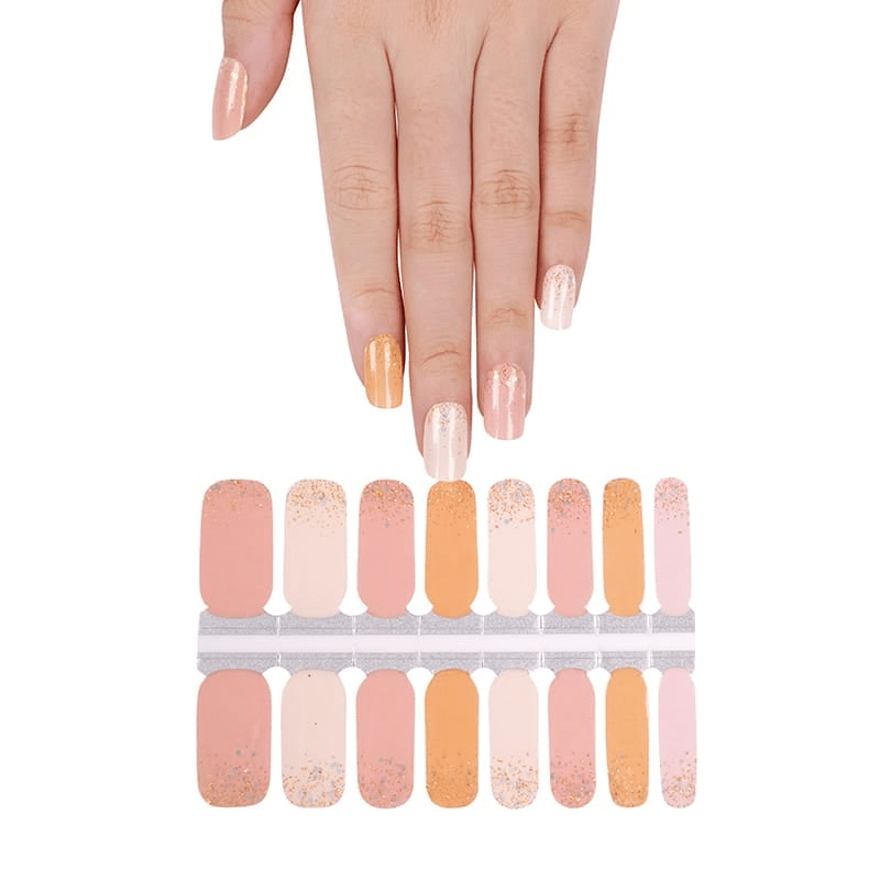 Hand above orange and cream nail wraps sheet showing gradient glitter designs