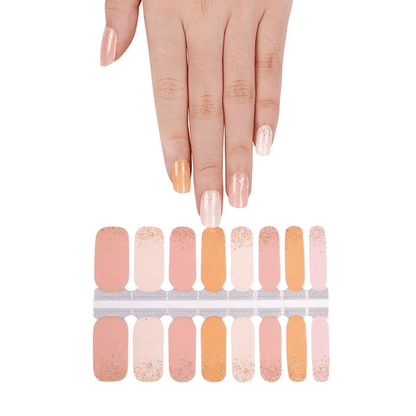 Hand above orange and cream nail wraps sheet showing gradient glitter designs