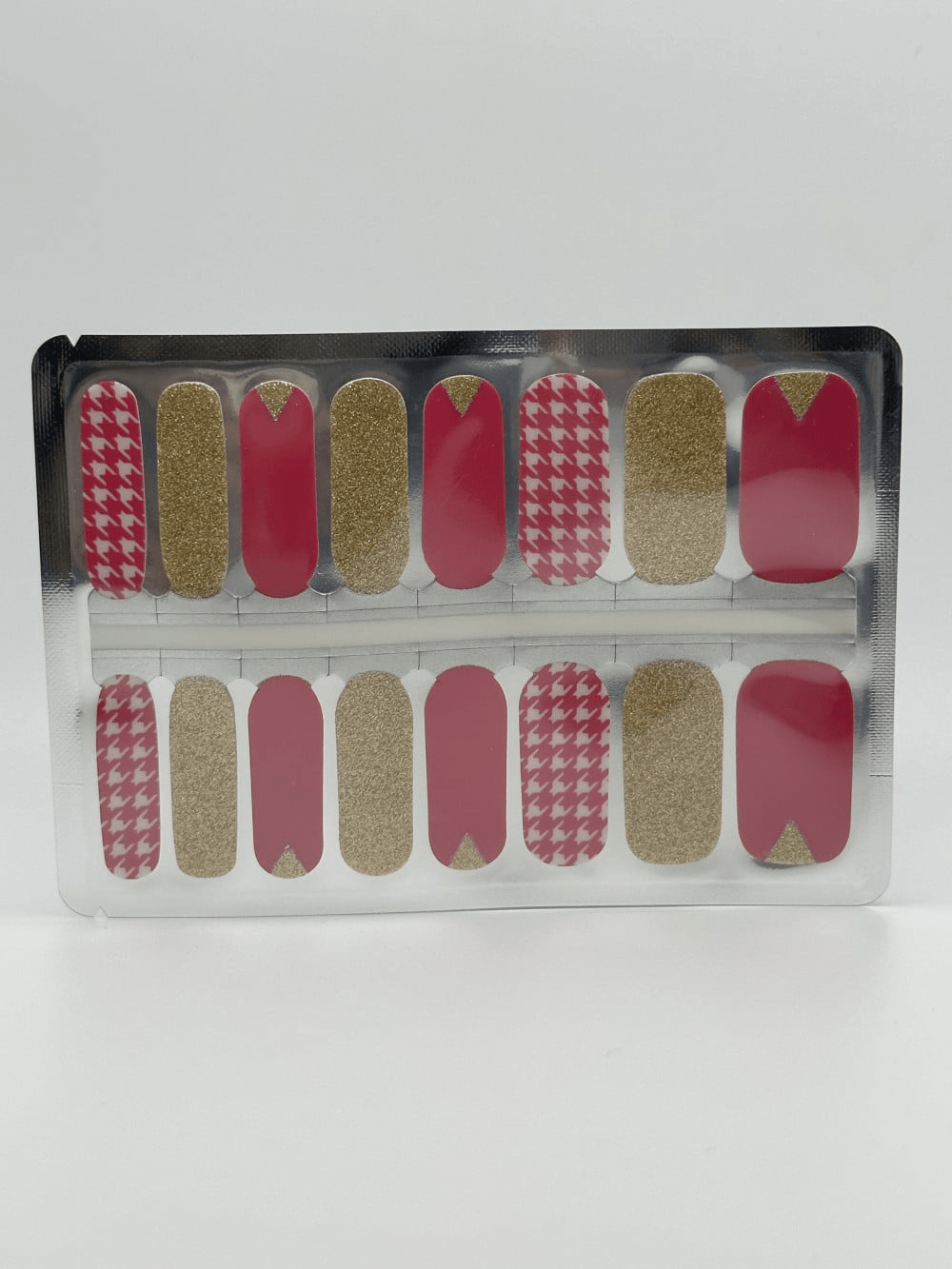 Complete set of pink and gold glitter houndstooth nail wraps in clear packaging