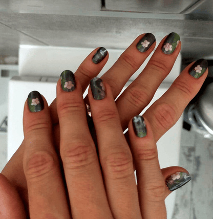 Hands wearing green tropical nail wraps with hummingbird and floral design for summer nail art