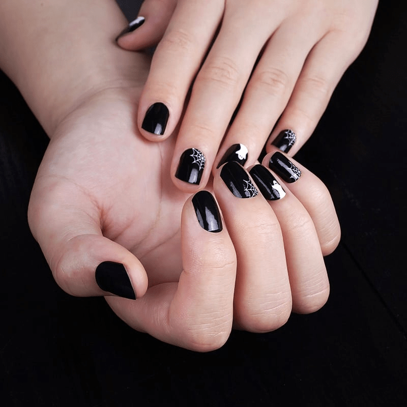 Black Halloween nail wraps with white ghost and spider web designs on hands