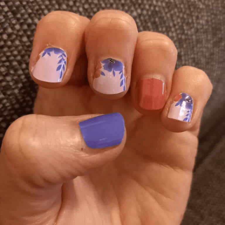 Hand displaying mixed manicure with purple coral and floral nail wrap designs