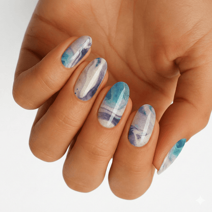 Blue marble nail wraps on hand showing abstract watercolour stone effect manicure design