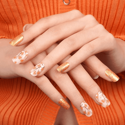 Autumn nail wraps with gold glitter and white maple leaves on hands