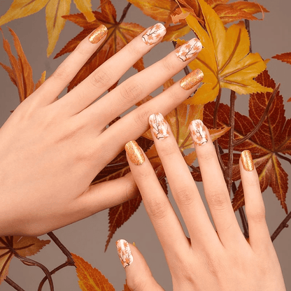 Nail wraps in orange glitter and white with maple leaf branch design