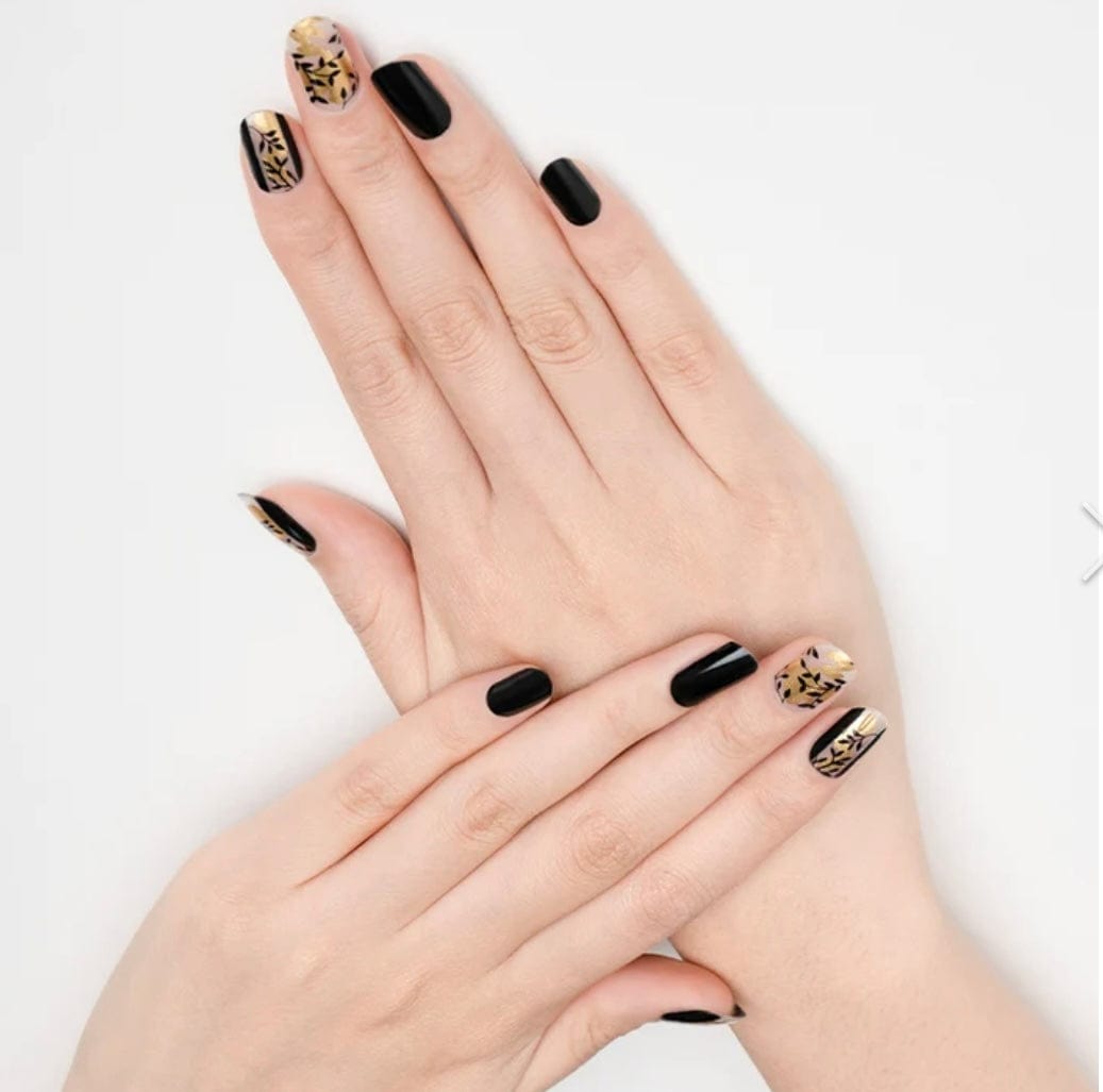 Black nail wraps with glossy finish, accent nails featuring gold leaf foil design