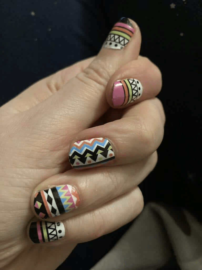 Boho tribal nail art wraps on hand with multicoloured chevron and geometric designs