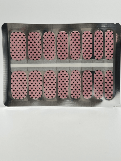 Non-UV nail wraps sheet with pink background and black heart pattern for at-home manicure
